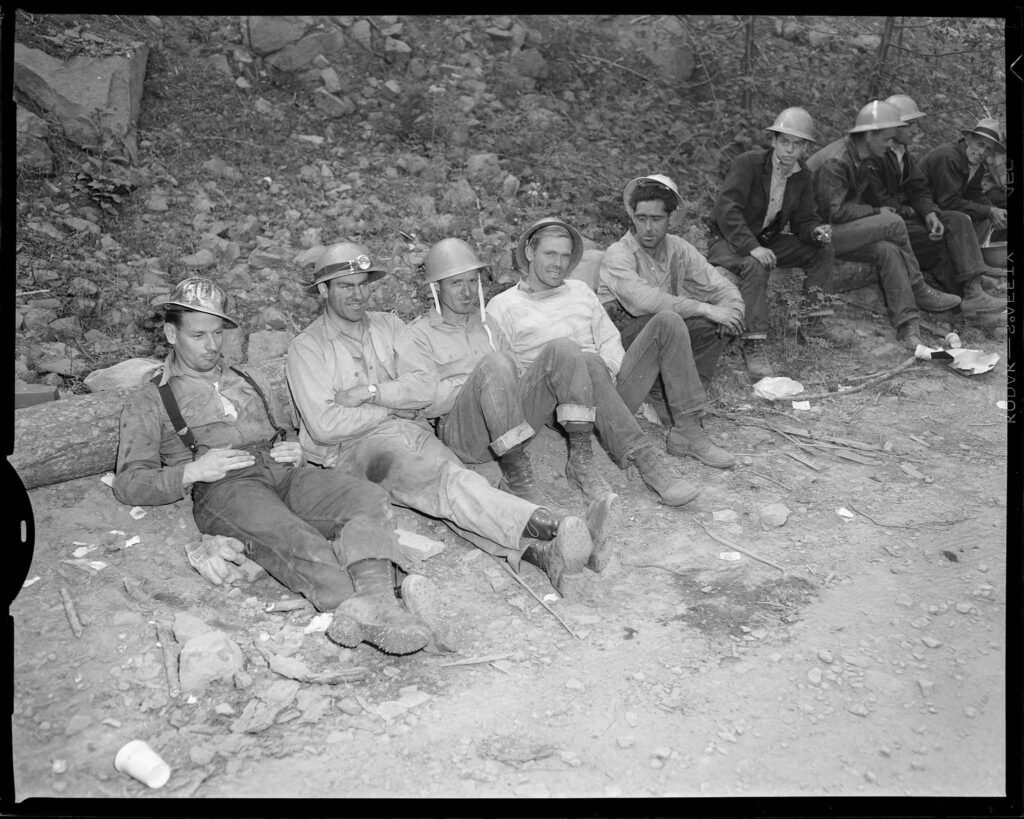 Tired from all-night battle against forest fire which blackened the butte north and east of Brightwood, crew headed by Eldon Stroup, (second from left), ranger from Umpqua National Forest, rests after coming off shift. Men are, (from left) John Burr, Ted Winter and Jim Hawkins. 